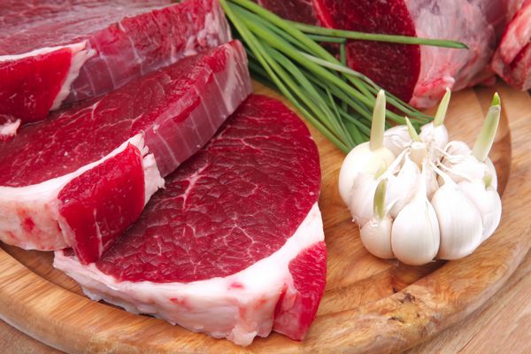 گوشت خام گوشت گاو تازه گوشت خوک دنده بزرگ و فیله با سیر و مواد سبز روی چوب جدا شده روی پس زمینه سفید