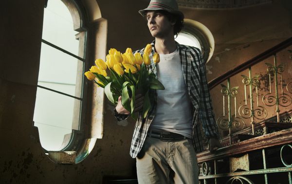 مرد رمانتیک دسته گل لاله در دست دارد
