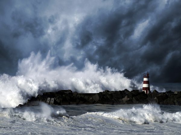 امواج طوفان بر فراز فانوس دریایی بندر povoa do varzim پرتغال - آسمان تقویت شده