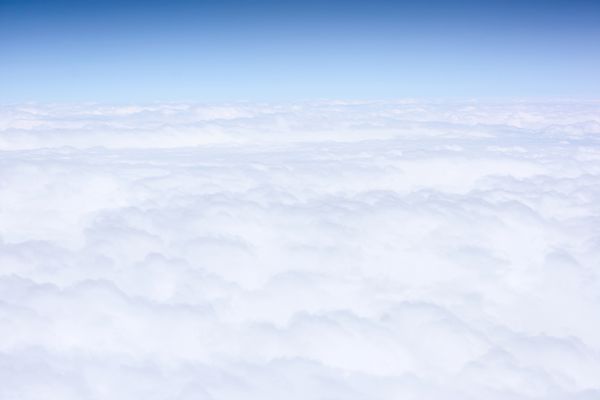 ابرهای سفید و آسمان آبی نمای از هواپیما