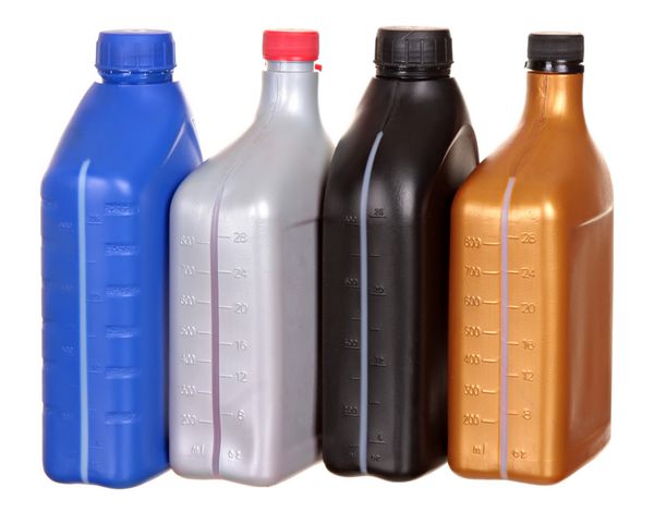 بطری های پلاستیکی از روغن های خودرو جدا شده در پس زمینه سفید