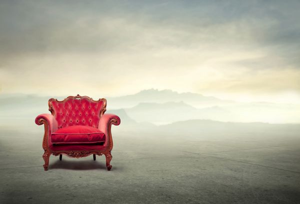 صندلی راحتی مخملی قرمز با منظره در پس زمینه