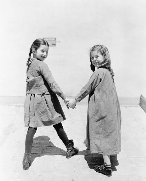 دو دوست دختر در حال راه رفتن و دست در دست هم هستند