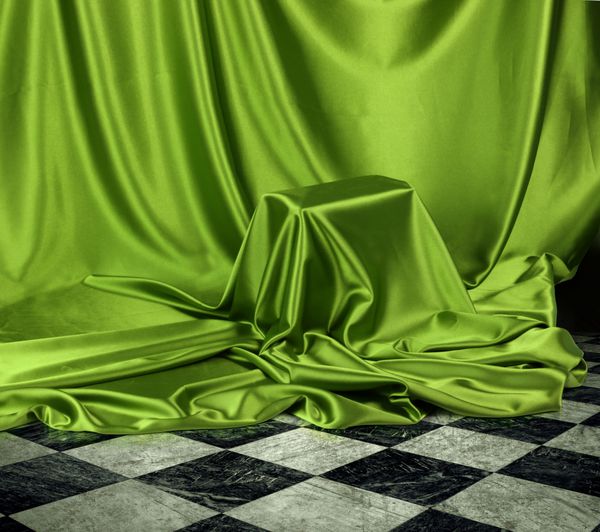 چیزی مخفی که زیر پارچه پارچه ابریشمی ساتن سبز پوشیده شده است