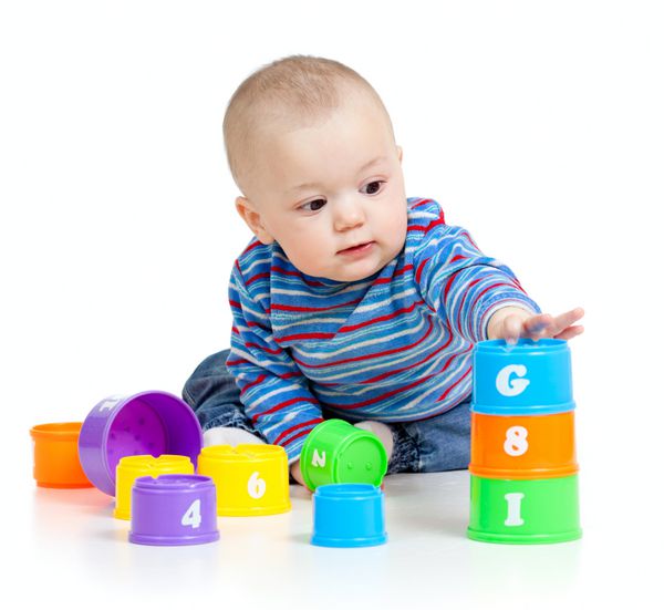 کودک با اسباب بازی های آموزشی روی زمینه سفید است