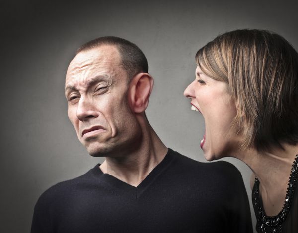 زن خشمگینی که بر علیه شوهرش فریاد می زند با f او که از قدرت فریاد تغییر شکل داده است