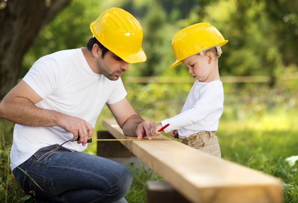 پسر کوچک به پدرش در کارهای ساختمانی کمک می کند