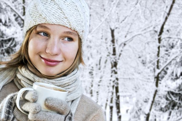 دختر نوجوان با کلاه زمستانی با فنجان شکلات