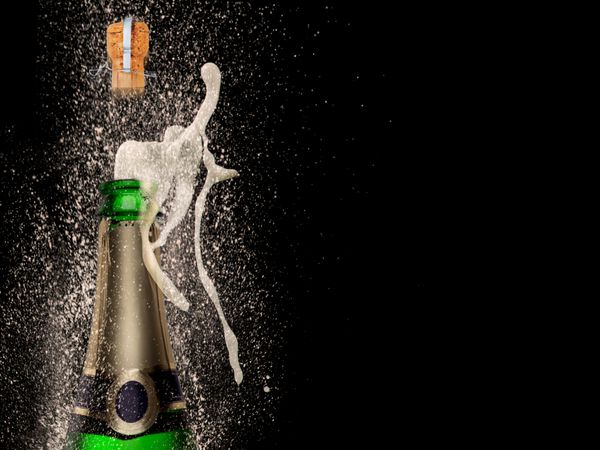 انفجار شامپاین در پس زمینه سیاه تم جشن