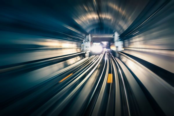 تونل مترو با خطوط نور تار با قطار ورودی در جهت مخالف - مفهوم حمل و نقل مدرن مترو زیرزمینی و سرعت اتصال