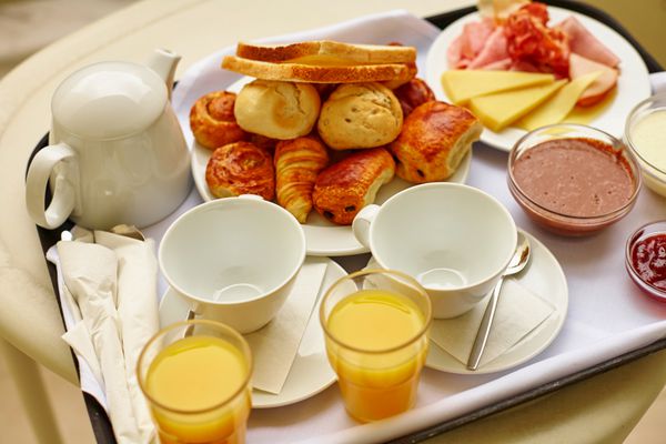 صبحانه خوشمزه با آب پرتقال تازه و شیرینی تمرکز بر فنجان های قهوه