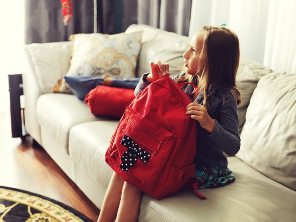 دختر بچه آماده مدرسه در خانه با کیف مدرسه