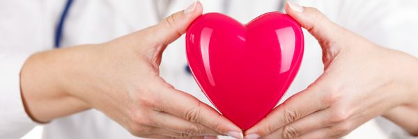 دست‌های پزشک زن که قلب اسباب‌بازی قرمز را در جلوی سینه‌اش نگه داشته است نمای صندوق نامه کمک پزشکی پیشگیری یا مفهوم بیمه مراقبت های قلب و عروق بهداشت حفاظت و پیشگیری
