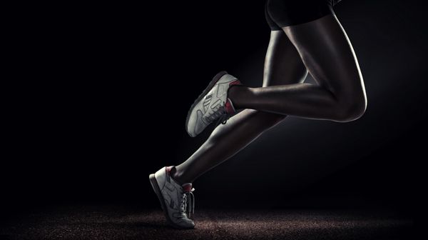 پس زمینه ورزشی دونده نمای جانبی پاهای دونده ایزوله شده روی مشکی