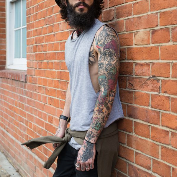 پرتره مرد جوان در برابر دیوار آجری در منطقه شوردیچ لندن انگلستان سبک هیپستر