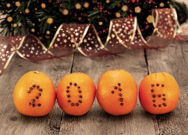 تزیینات سال نو با پرتقال و تعداد میخک روی زمینه چوبی