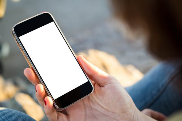 نمای نزدیک زن جوان با استفاده از تلفن همراه خود با صفحه خالی