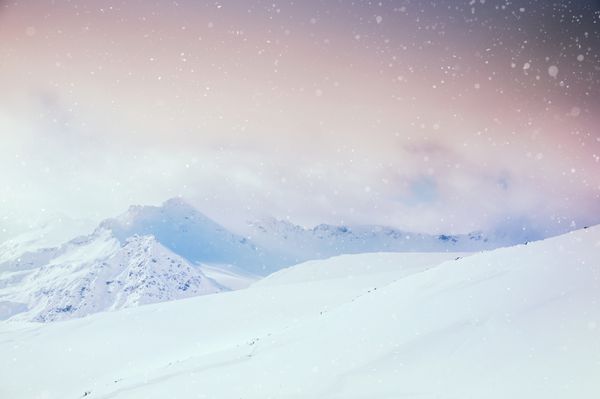 منظره زمستانی زیبا با کوه های پوشیده از برف در غروب آفتاب