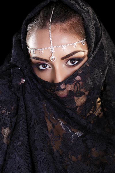 پرتره یک زن زیبا با آرایش عربی در پارانجا مشکی جدا شده در پس زمینه تیره