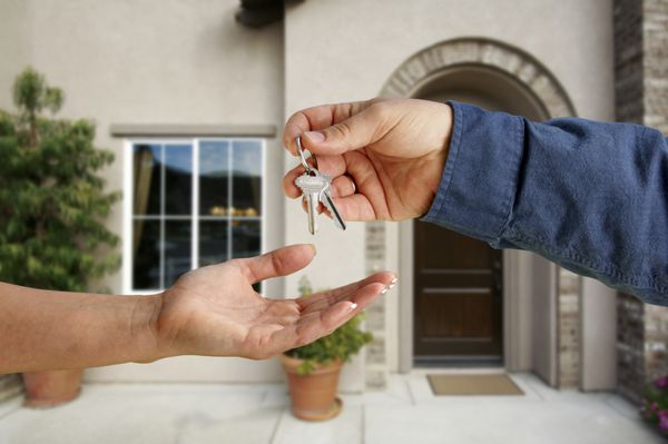 تحویل دادن کلیدهای خانه در مقابل یک خانه جدید زیبا