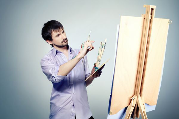 پرتره یک هنرمند که روی سه پایه نقاشی می کند در یک استودیو