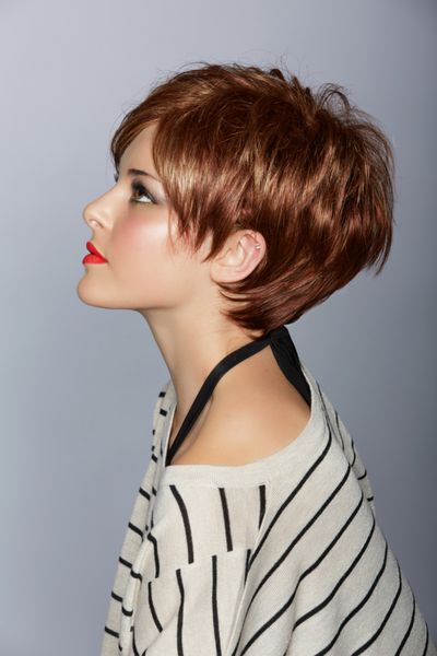 نمایه زنی زیبا با لب های قرمز و موهای قرمز پر پر کوتاه در باب مدرن روی پس زمینه استودیو