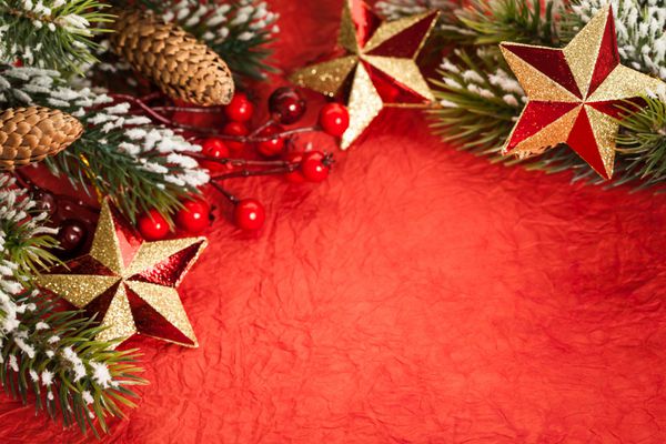 حاشیه از تزئینات درخت کریسمس روی کاغذ قرمز