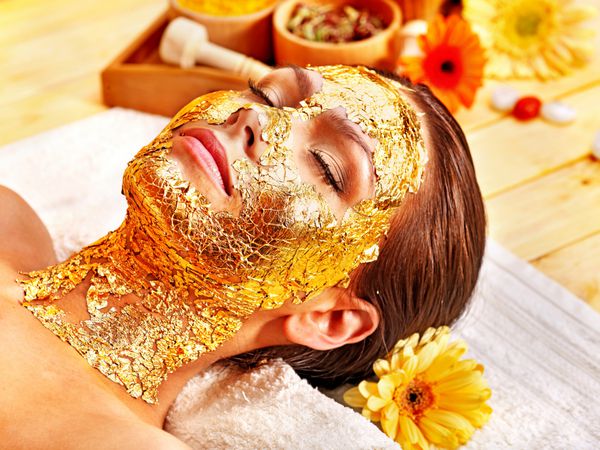 زنی که ماسک صورت طلا می گیرد