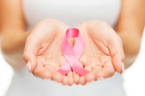 مفهوم مراقبت های بهداشتی و پزشکی - دست های زنی که نوار آگاهی از سرطان سینه صورتی را در دست دارند