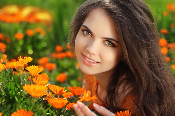 دختر خندان شاد پرتره زیبای عاشقانه زن در فضای باز بر فراز مزرعه گل همیشه بهار موهای بلند سالم لذت بردن