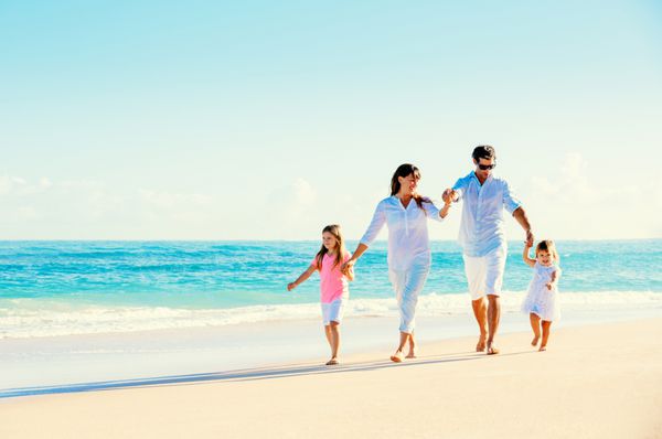 خانواده شاد در حال تفریح در ساحل آفتابی زیبا