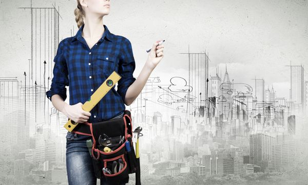 زن جوان مکانیک با خط کش در دست در پس زمینه شهر
