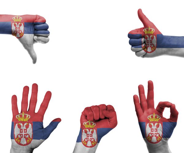 مجموعه ای از دست ها با حرکات مختلف در پرچم صربستان پیچیده شده است