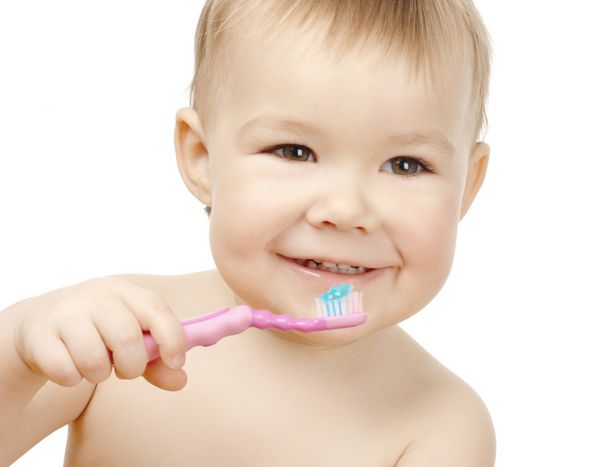 کودک ناز تمیز کردن دندان و لبخند جدا شده بر روی سفید