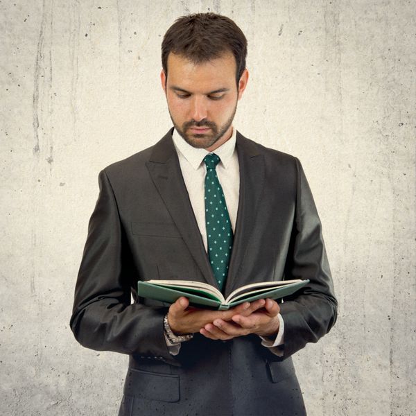 مرد تجاری در حال خواندن کتاب بر روی پس‌زمینه مجزا