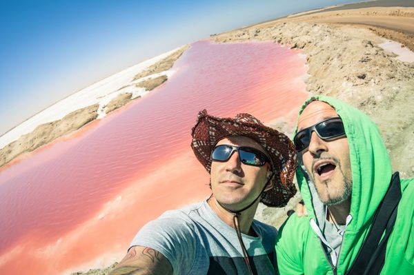 بهترین دوستان هیپستر ماجراجو در Walvis bay pink saline در نامیبیا - سبک زندگی در سفر سرگردان به اشتراک گذاری لحظات شاد با روندهای جدید و فناوری های مدرن - سلفی چشم ماهی با افق کج