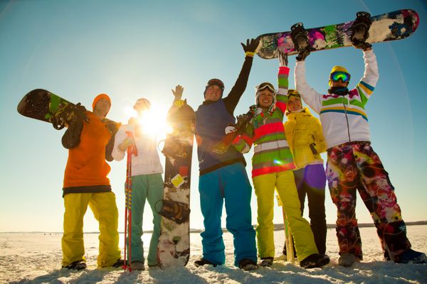 گروهی از جوانان با اسنوبرد در تعطیلات اسکی در کوهستان