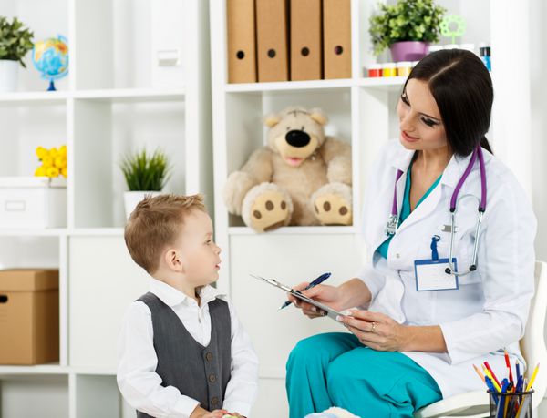 معاینه پزشک خانواده کودک کوچک در حال ملاقات با پزشک اطفال پزشک زن زیبا با کک و مک در حال ارتباط با بیمار جوان ناز مفهوم پزشکی کودکان