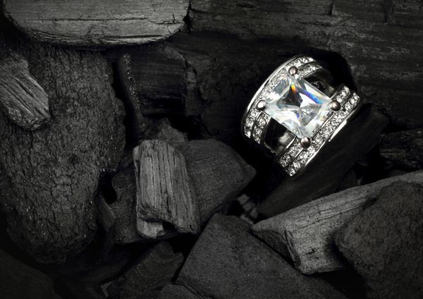 انگشتر جواهر با الماس رنگارنگ بزرگ در زمینه زغال سنگ تیره