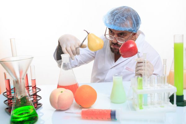دانشمند مواد شیمیایی میوه و سبزیجات را پر می کند