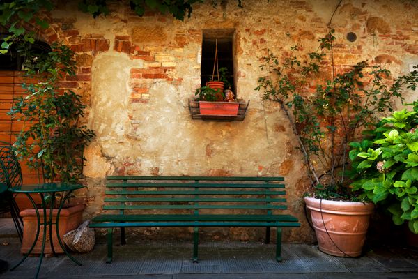 نیمکت رترو بیرون خانه قدیمی ایتالیایی در شهر کوچک پیانزا ایتالیا تزئینات گیاهی قدیمی