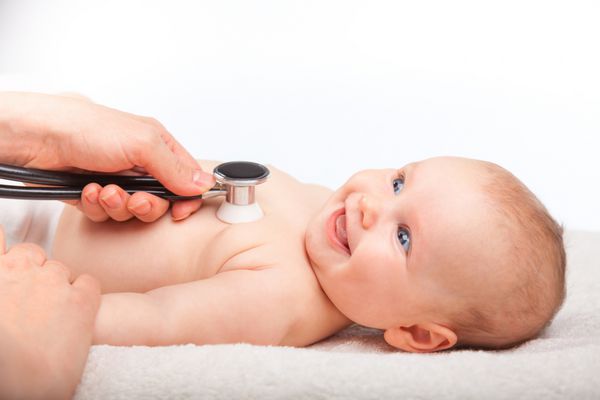 نمای نزدیک پزشک اطفال دختر سه ماهه را معاینه می کند دکتر با استفاده از گوشی پزشکی برای گوش دادن به قفسه سینه نوزاد و بررسی ضربان قلب