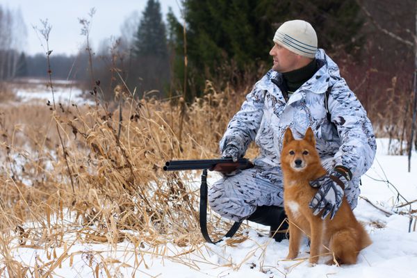 شکارچی با سگ در زمین برفی