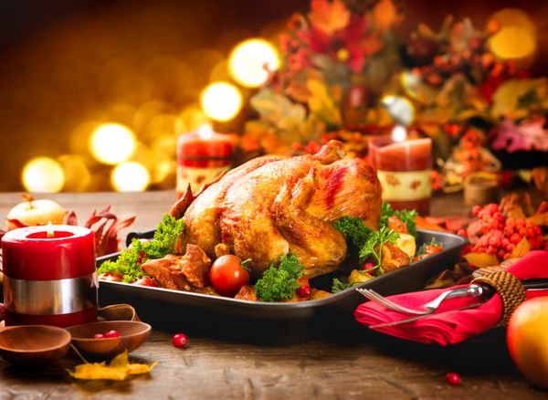 بوقلمون کبابی میز شکرگزاری که با بوقلمون سرو می شود تزئین شده با برگ های درخشان پاییزی و شمع ها مرغ سوخاری سفره آرایی شام کریسمس