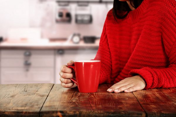 لیوان قهوه زن رنگ قرمز در مبلمان قرمز و آشپزخانه
