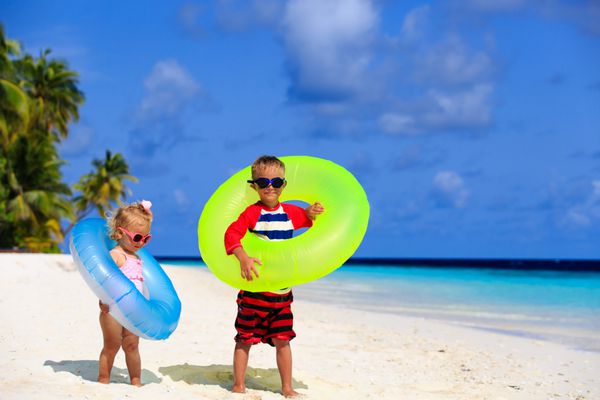 بازی پسر کوچک و دختر نوپا در ساحل استوایی