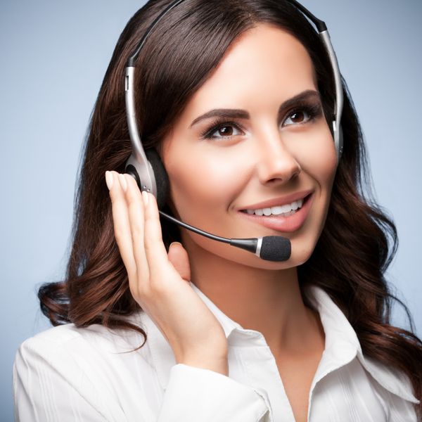 اپراتور تلفن زن با پشتیبانی مشتری در هدست در پس زمینه خاکستری مرکز تماس خدمات مشاوره و کمک