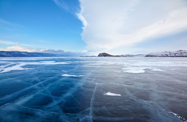 منظره یخی زمستانی در دریاچه بایکال سیبری با ابرهای آب و هوایی چشمگیر جلوی طوفان