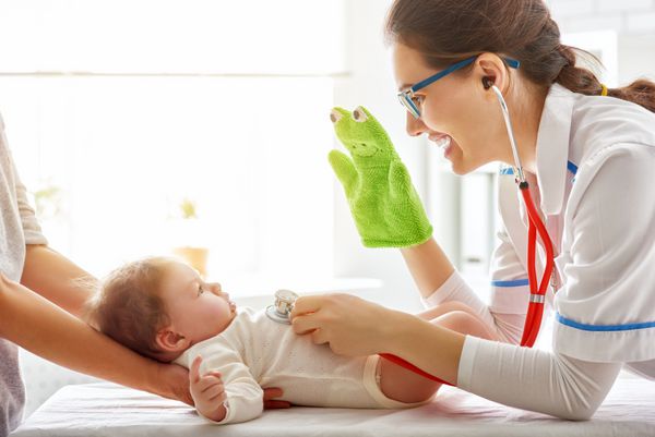 پزشک در حال معاینه نوزاد در بیمارستان