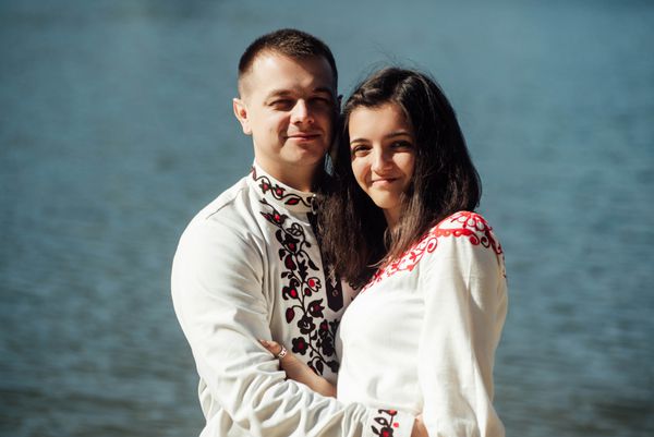 عروس زیبا و داماد شیک با احساسات واقعی در نزدیکی دریاچه آفتابی مفهوم شادی